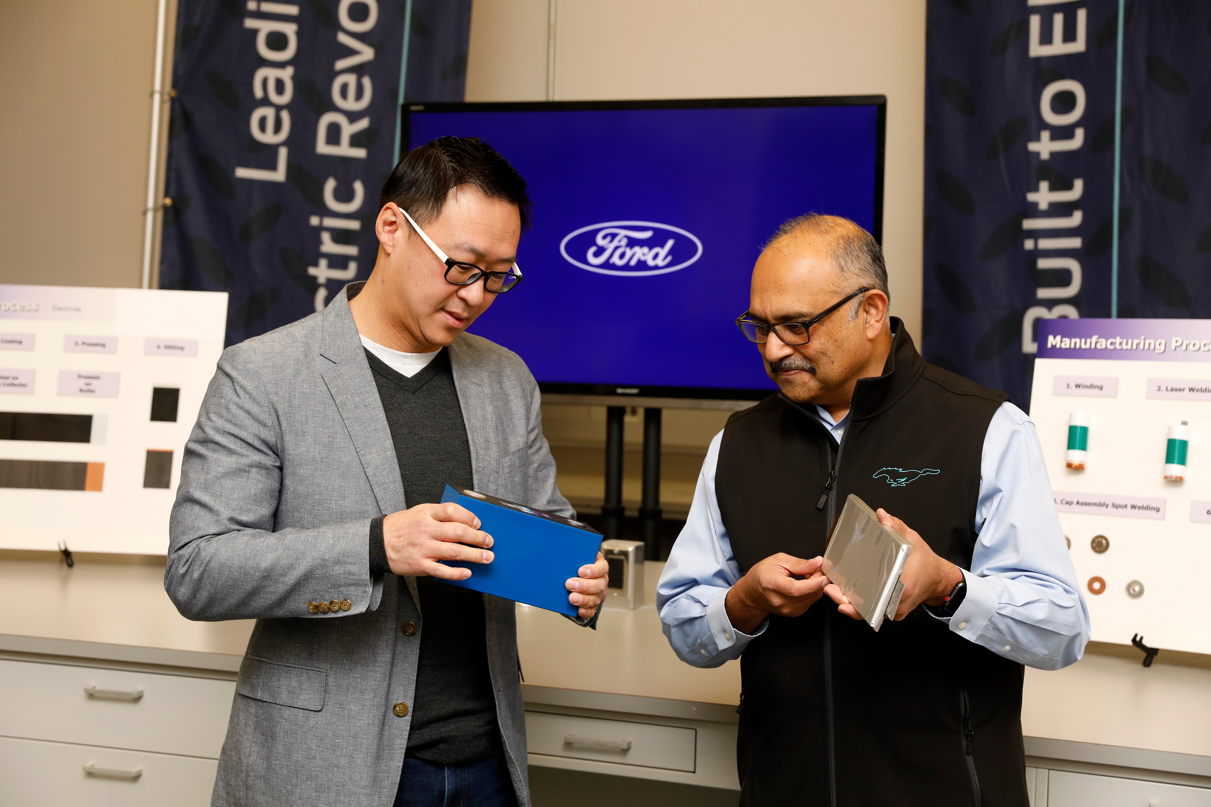 Charles Poon, Director, Electrified Systems Engineering, Ford Motor Company, holds a lithium iron phosphate (LFP) battery, while Anand Sankaran, Director, Ford Ion Park, Ford Motor Company, holds a nickel cobalt manganese (NCM) battery. Ford currently uses NCM in its electric vehicles, and will add LFP to its lineup beginning later this year to help it produce more EVs and make them more accessible and affordable for customers.